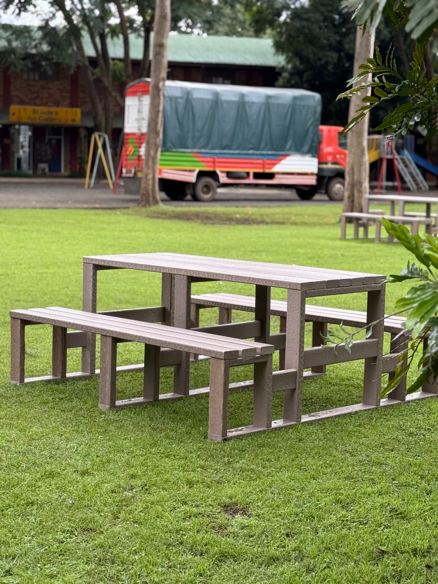 Brown recycled plastic picnic table and benches on a school lawn in Arusha
