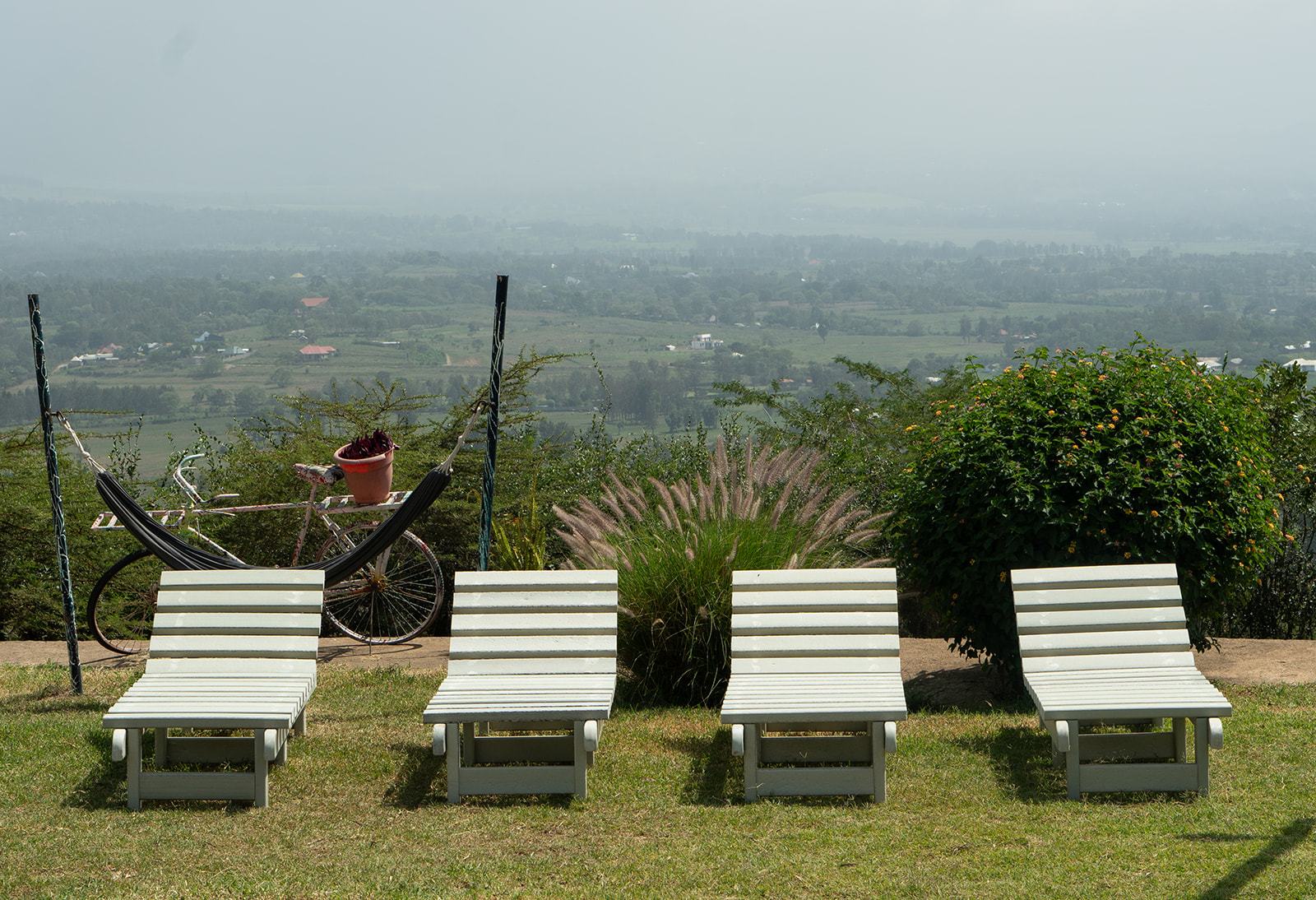 Recycled plastic sun loungers lined up on a hillside lawn overlooking the valley
