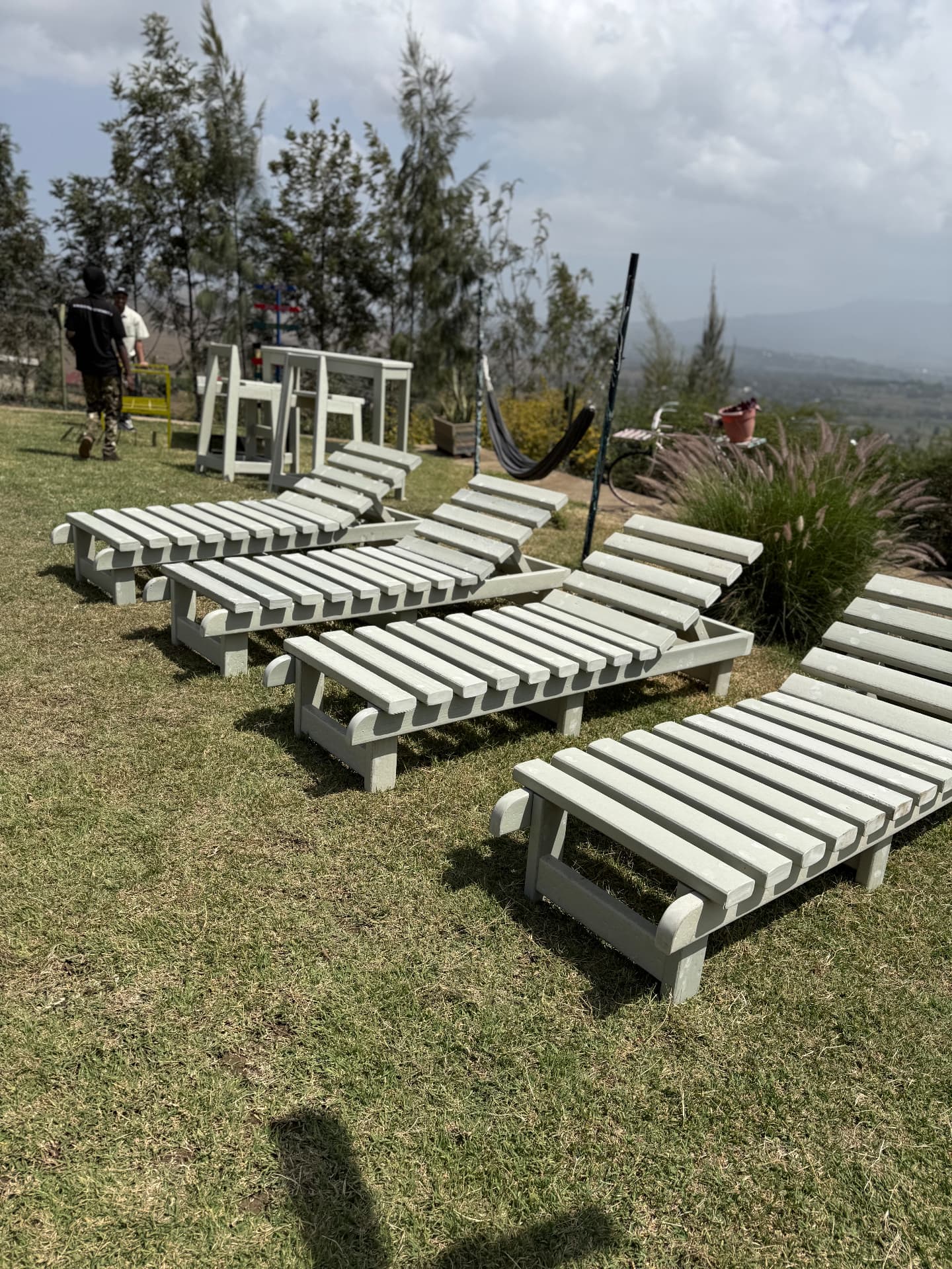 Light grey recycled plastic sun loungers arranged on a hotel lawn overlooking the valley