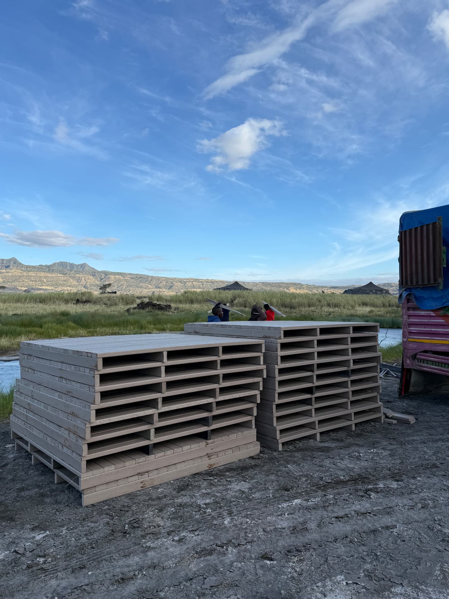 Stacks of prefabricated recycled plastic deck panels delivered to the Lake Natron camp site