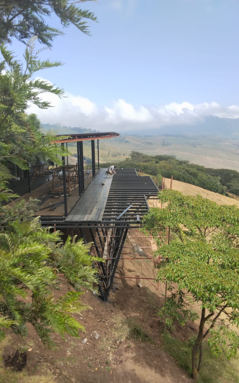 Recycled plastic deck boards being laid over a steel frame on a hillside lodge terrace