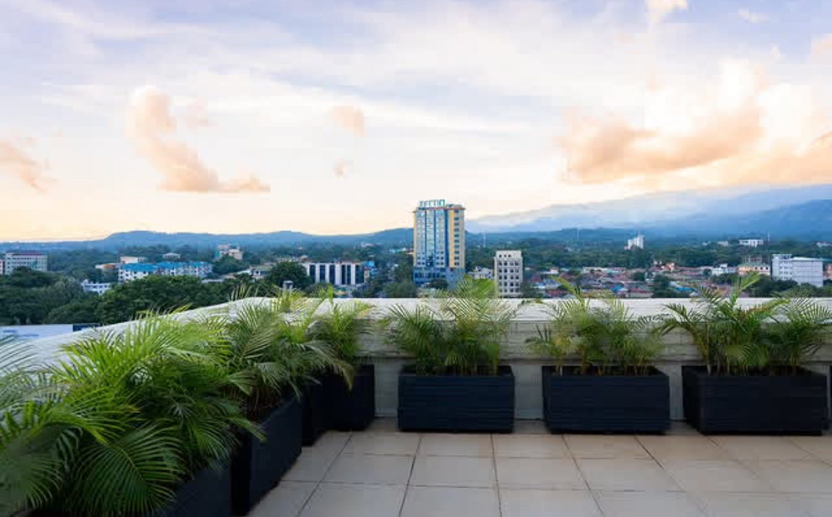 Recycled plastic planter boxes lining a rooftop terrace overlooking Arusha at sunset