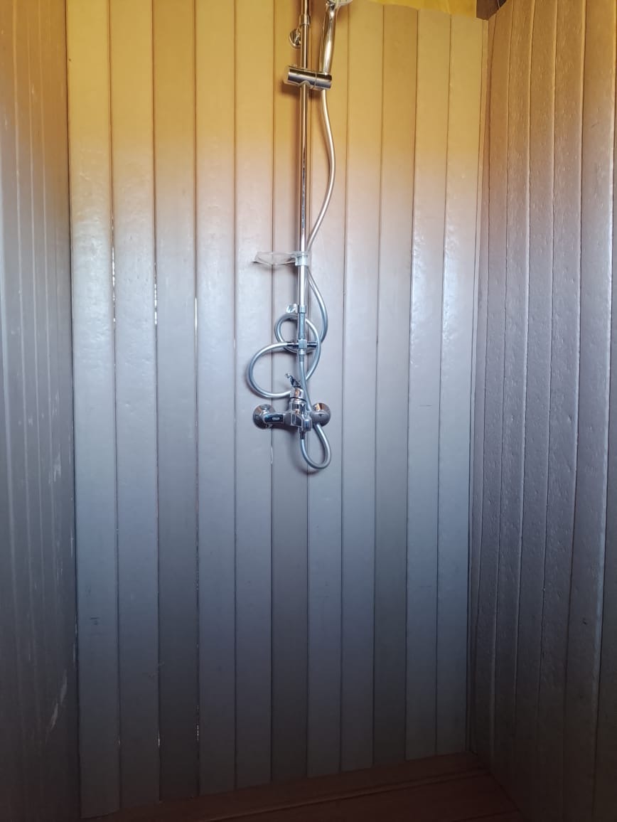 Recycled plastic cladding boards forming a washable shower wall in a safari camp