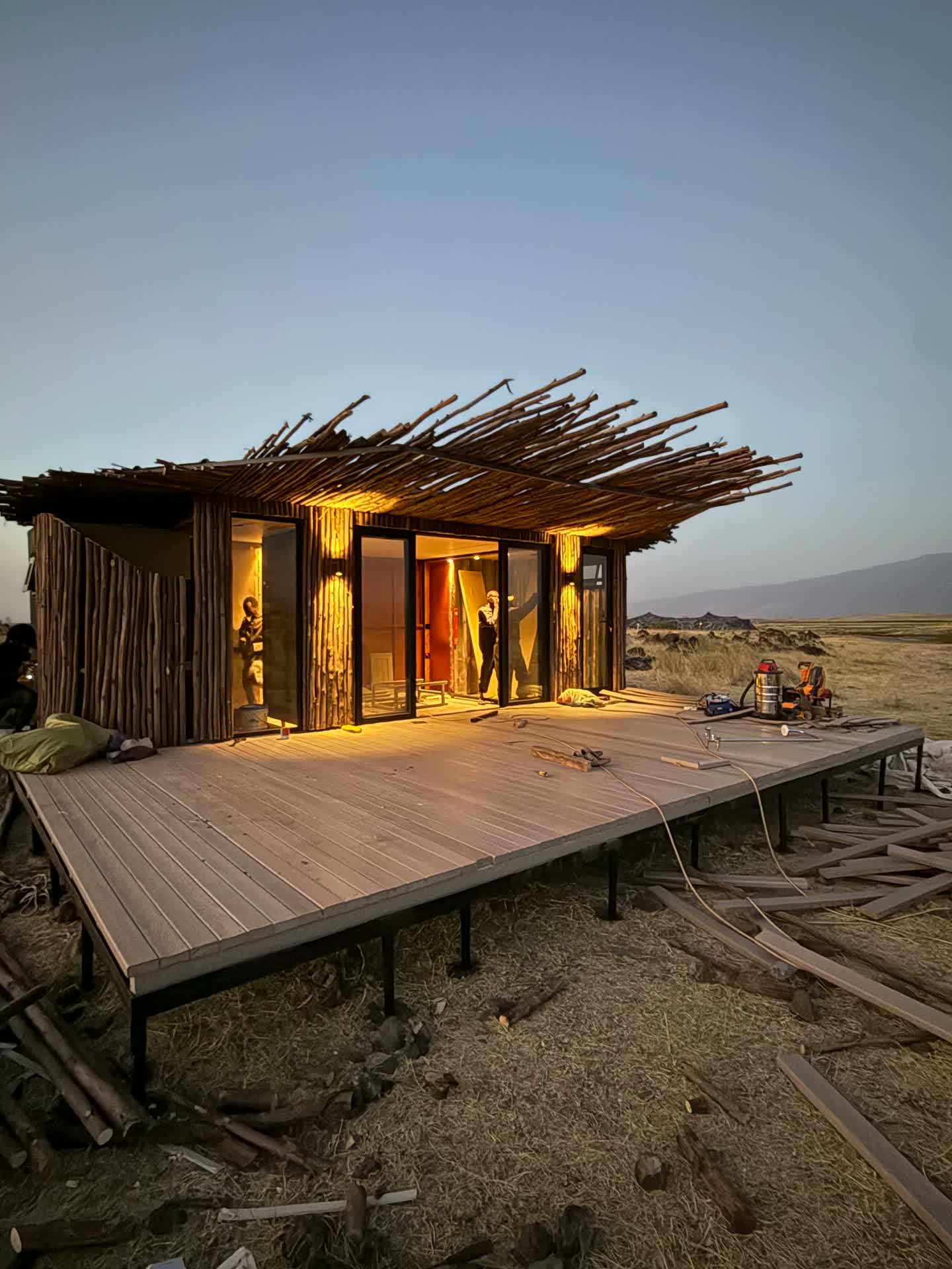 Completed recycled plastic deck wrapping a timber-clad guest villa at dusk, Lake Natron