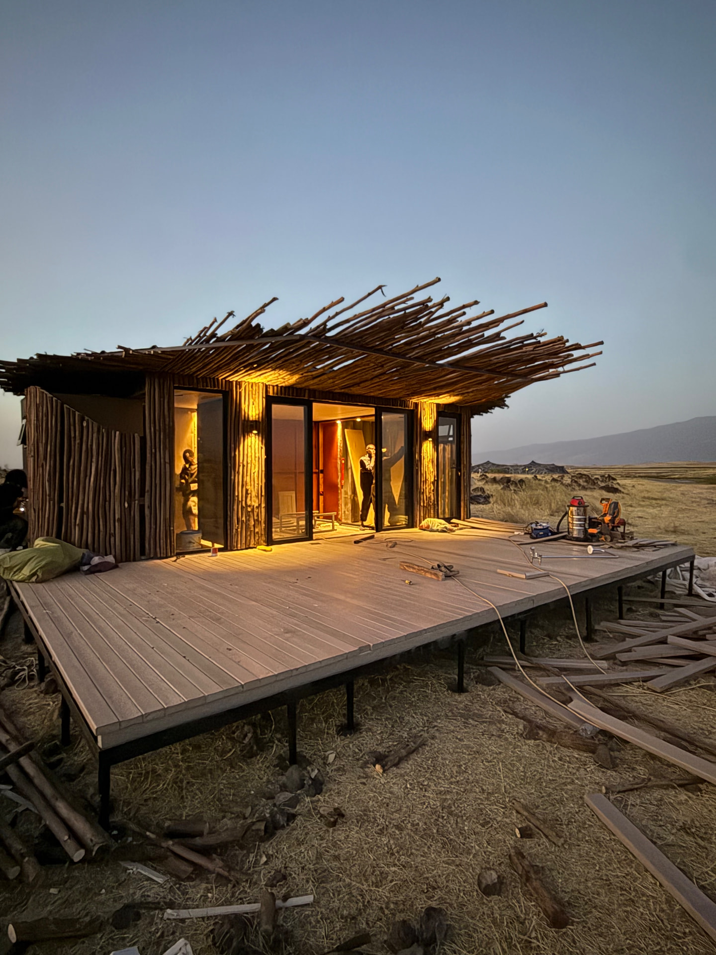 Camp villa on a recycled plastic deck platform at dusk, Lake Natron