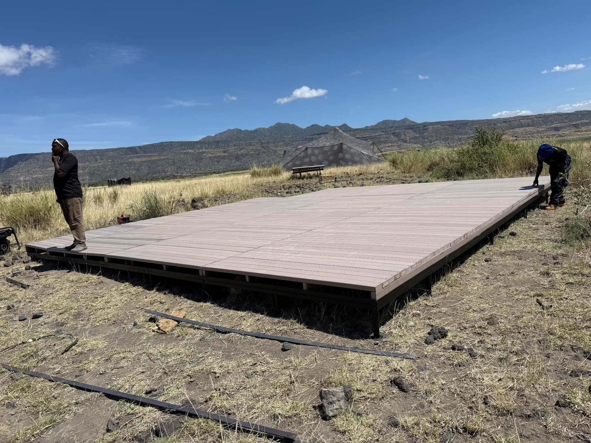 Completed recycled plastic deck platform at a Lake Natron camp with the escarpment behind